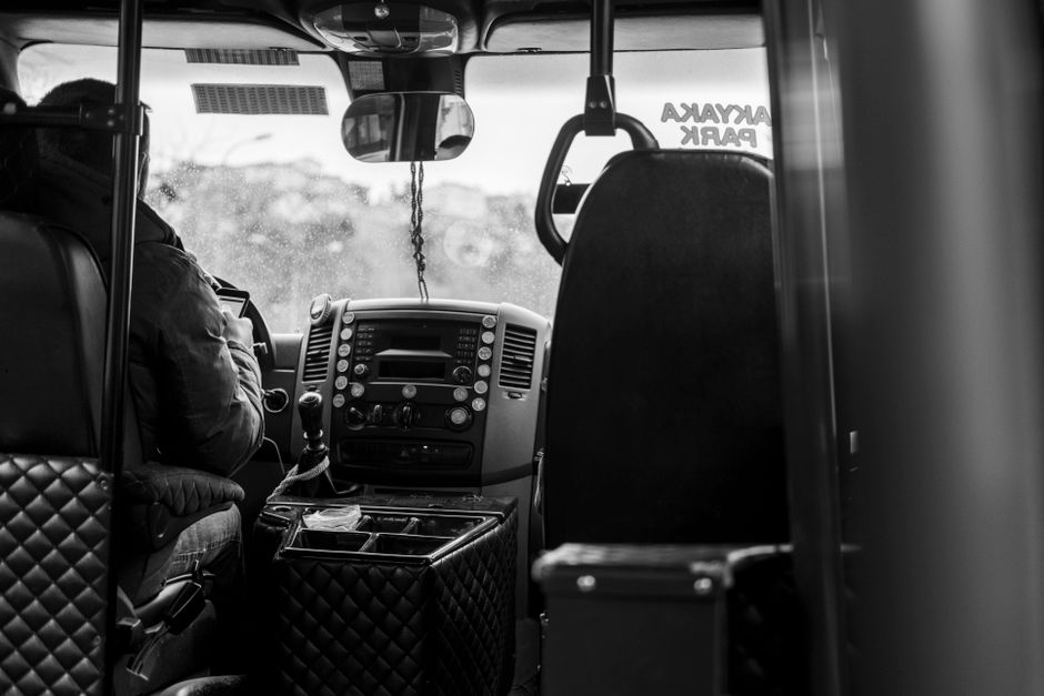Een buschauffeur die een volle bus veilig door de stad rijdt, met aandacht voor de verkeerssituatie.